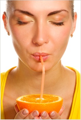 Žena pijúca z pomaranča